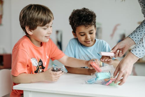 Free 2 Boys Sitting at the Table and Taking Plasticine  Stock Photo