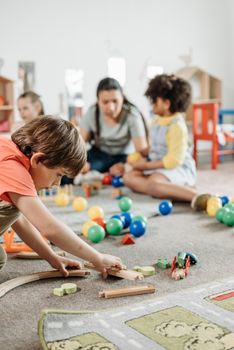 Children interacting with toys in a vibrant kindergarten setting, focusing on creativity and learning.