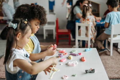 2 Girls Sitting at the Table and Sculpt from Plasticine 