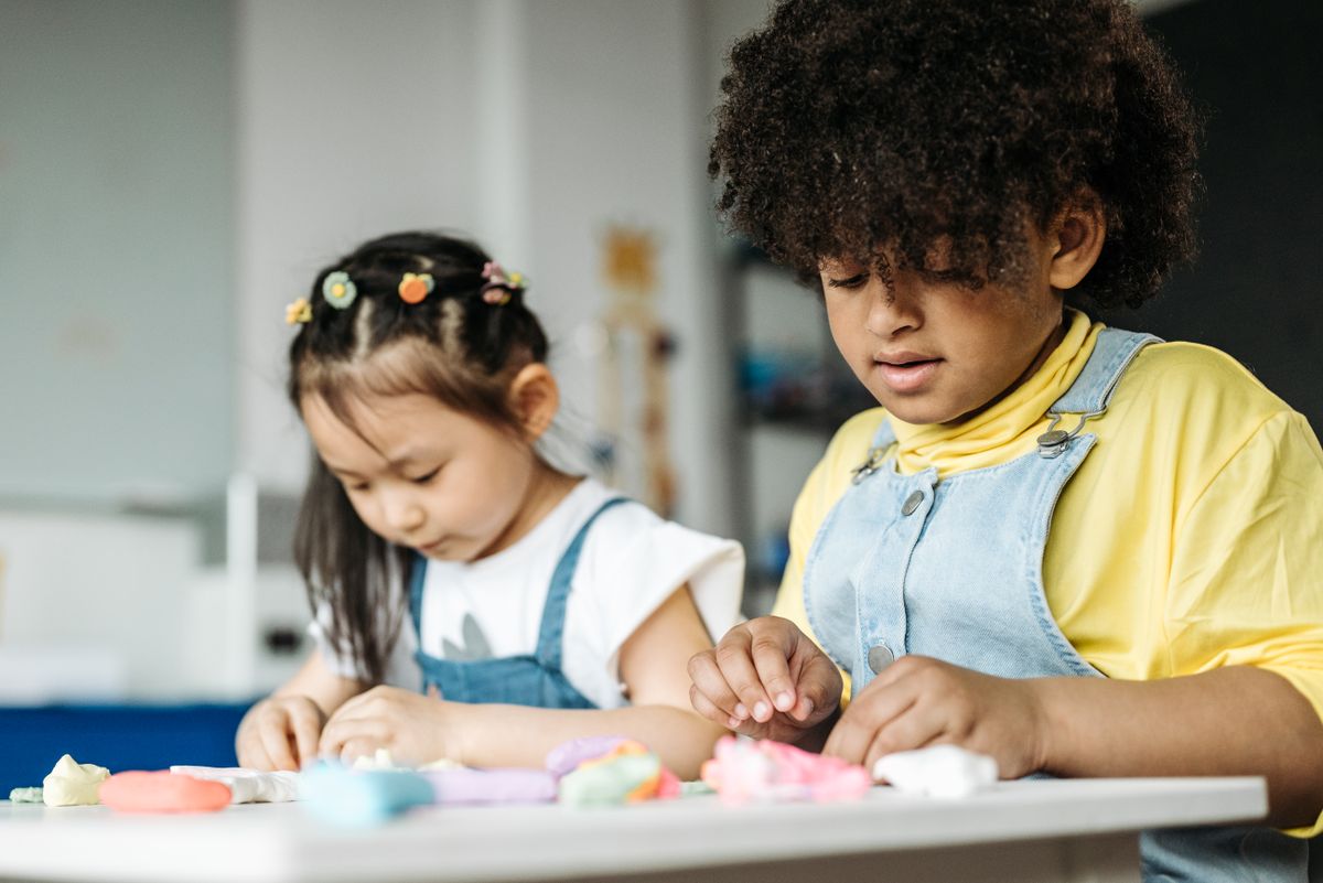 Children using hands-on creative materials together at a table