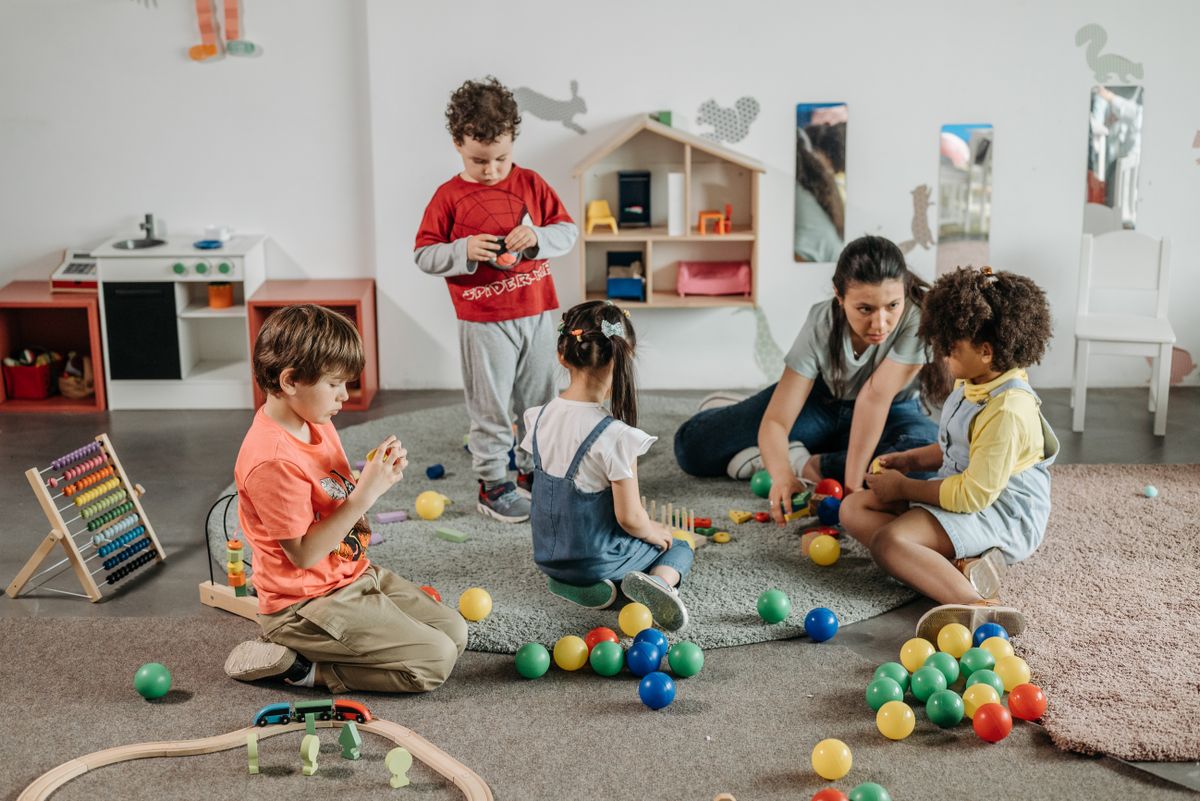 Professionnelle de la petite enfance jouant avec des enfants en crèche