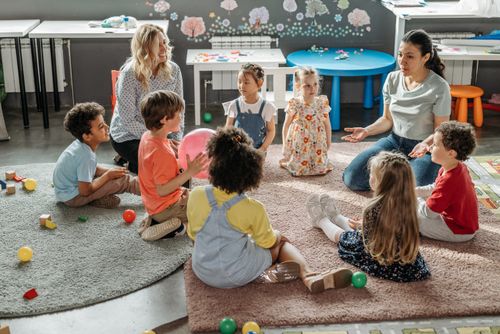 Free Children in circle time with teachers, engaging in a kindergarten classroom activity. Stock Photo