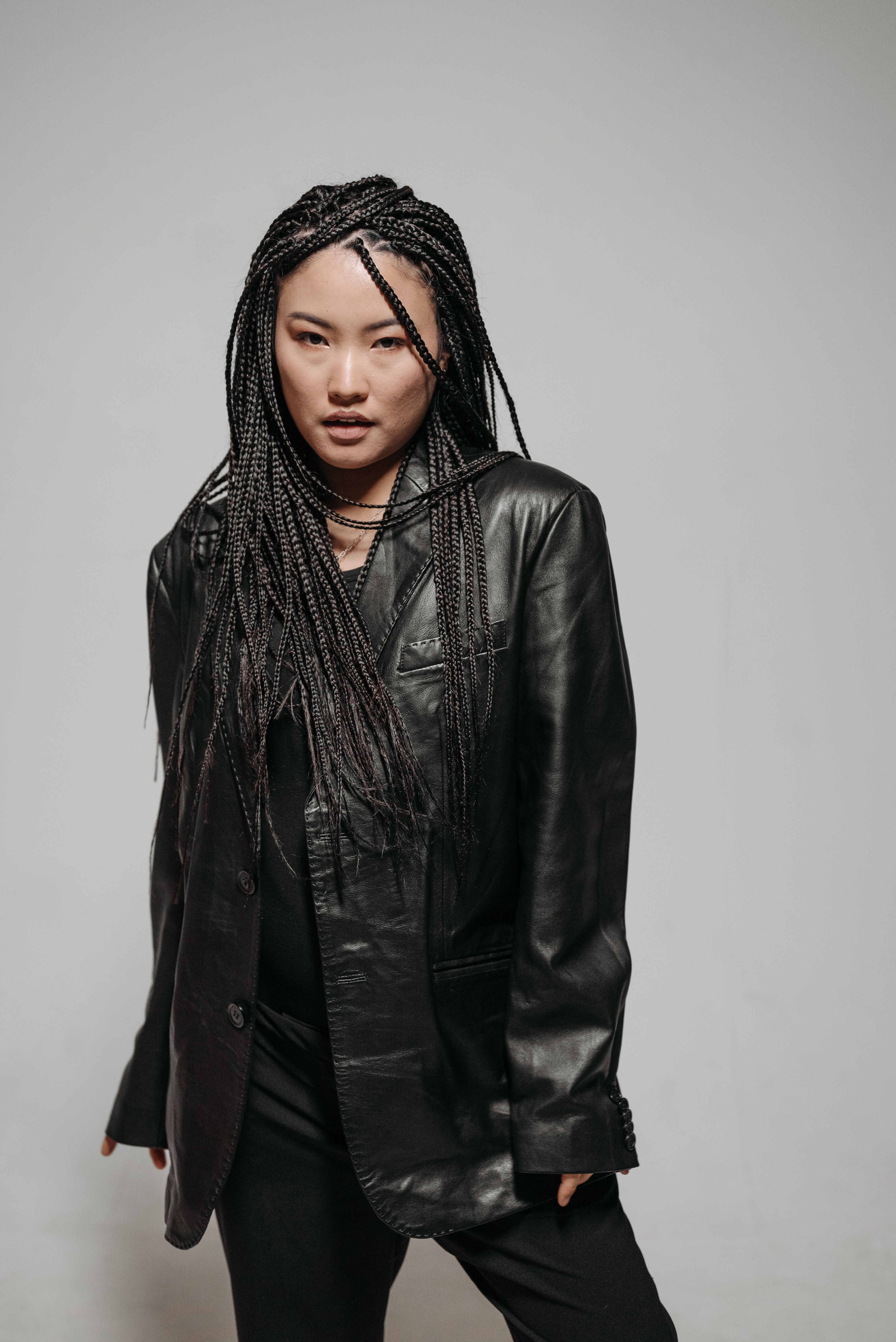 A Woman in a Black Leather Jacket Sitting on a Stool · Free Stock Photo