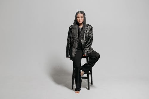 Woman in Black Leather Jacket Sitting on Bar Stool