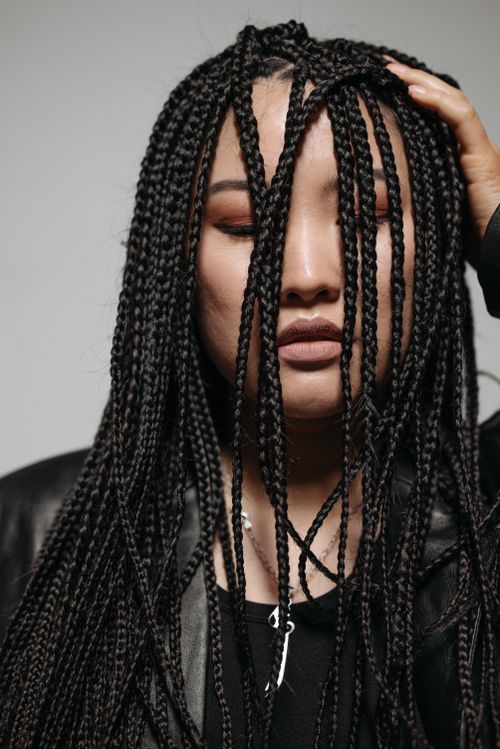 Free Close-up portrait of a woman with long braided hairstyle, showcasing beauty and style. Stock Photo