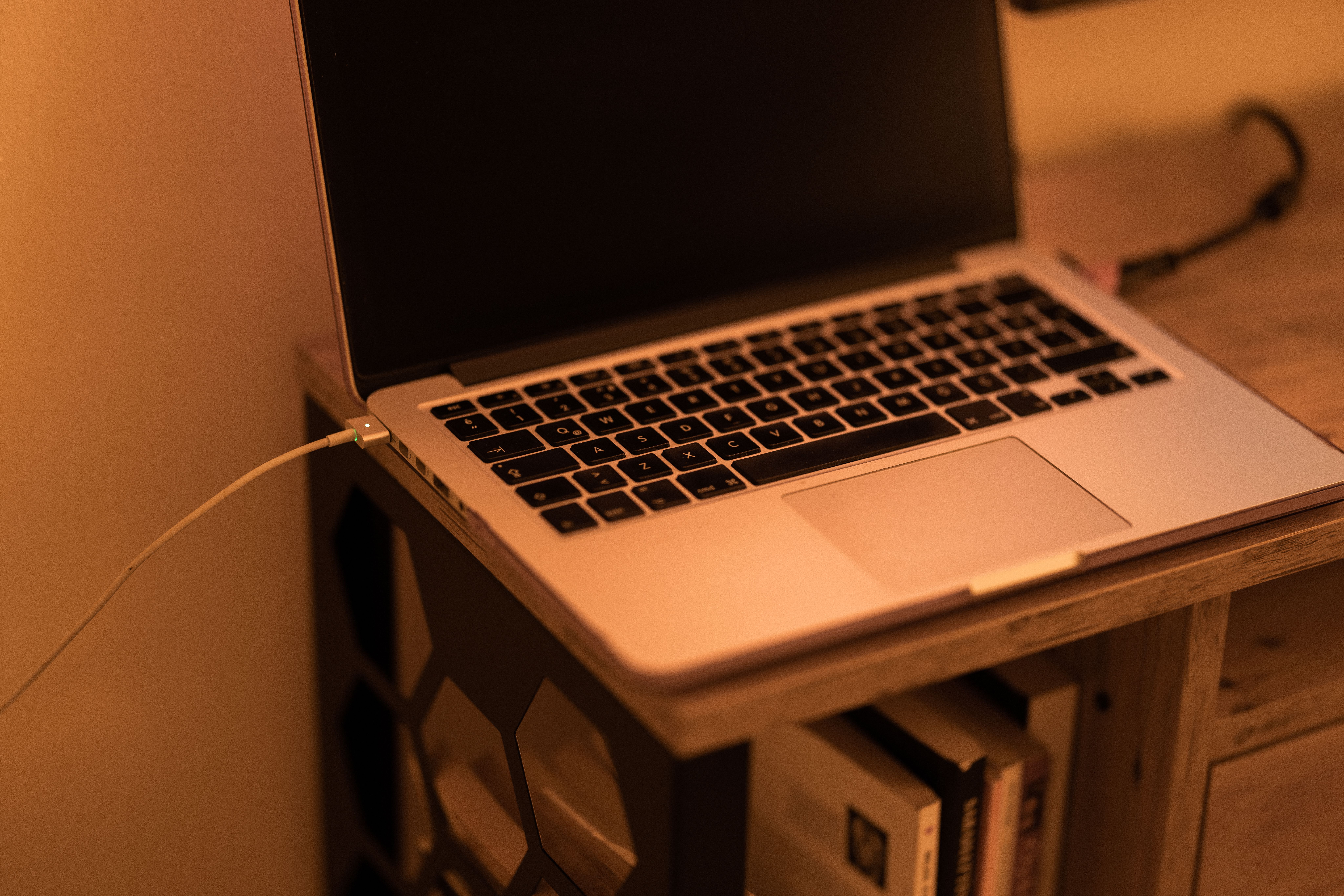 A modern laptop on a stylish wooden desk with warm ambient lighting, perfect for work-from-home setups.