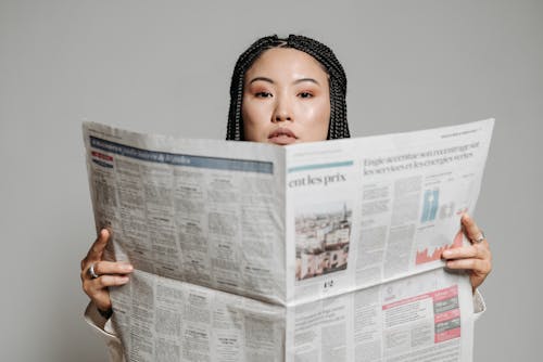 Free Woman with Braided Hair Holding Newspaper Stock Photo