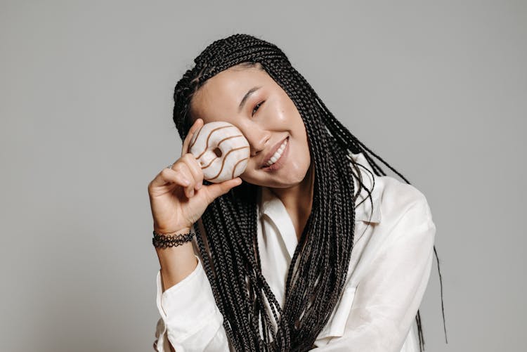 A Woman Covering Her Eye With Doughnut