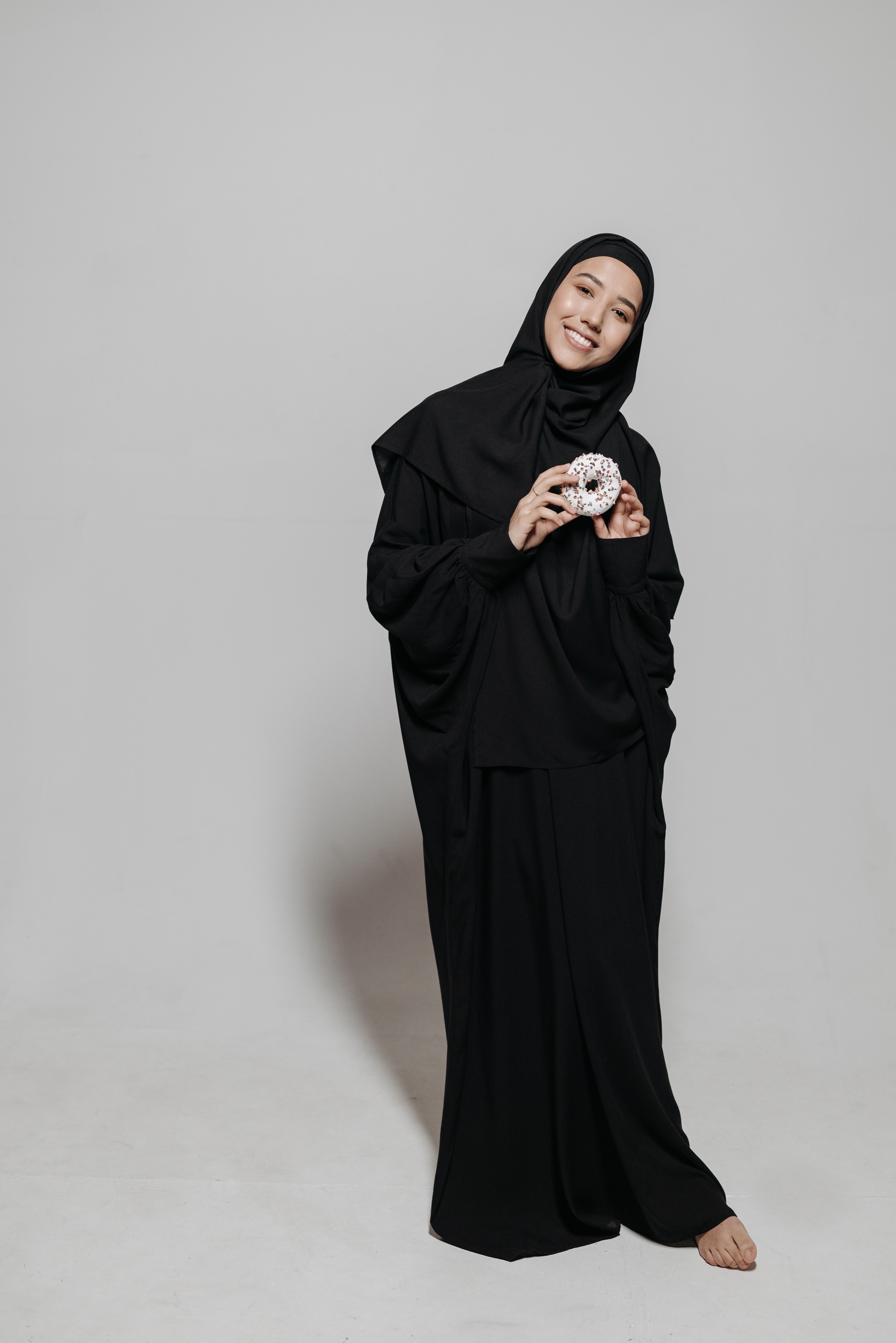 Woman in Black Hijab holding a Doughnut · Free Stock Photo