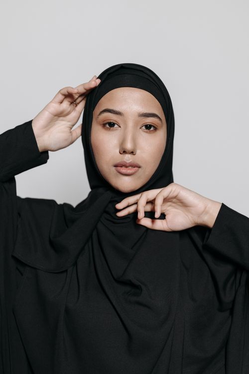 Free Elegant studio portrait of a woman wearing a black hijab and abaya, showcasing grace. Stock Photo