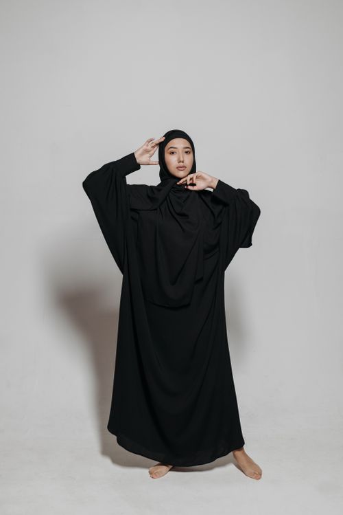 Free Elegant woman in a black hijab posing gracefully in a studio setting. Stock Photo