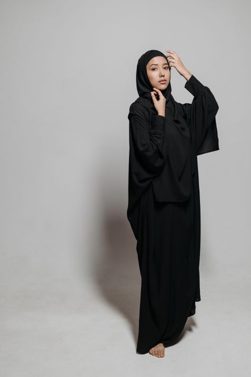 Free Portrait of a woman wearing a black abaya in a studio setting, exuding elegance and tradition. Stock Photo