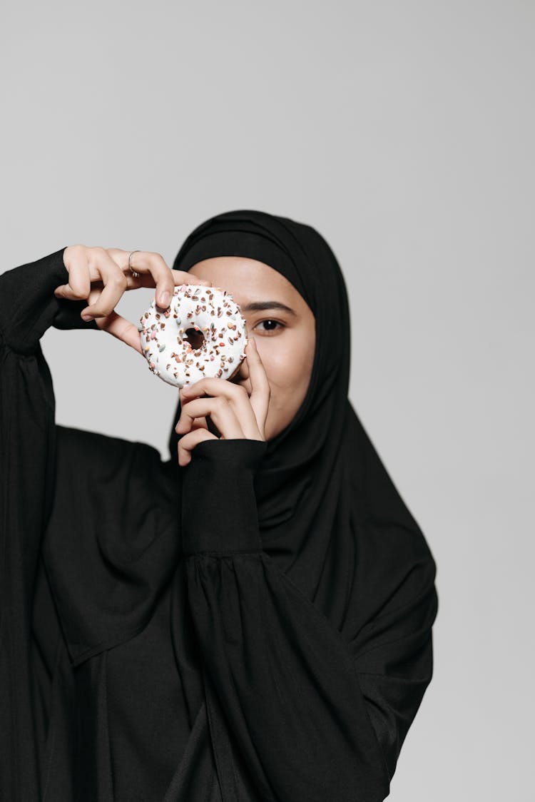 A Woman Holding A Doughnut 