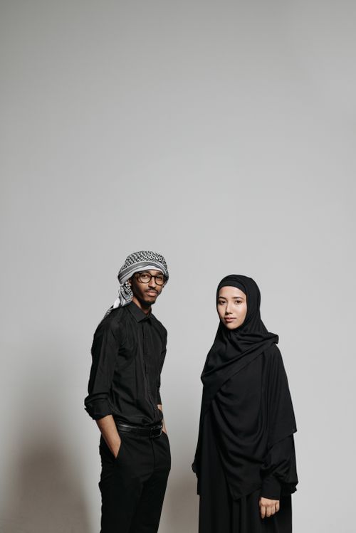 Free Studio shot of a man and woman in traditional attire, posing against a gray background. Stock Photo