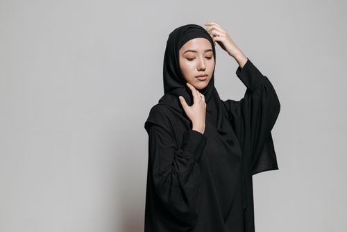 Free Captivating studio portrait of an adult Muslim woman wearing a black hijab, exuding elegance and serenity. Stock Photo