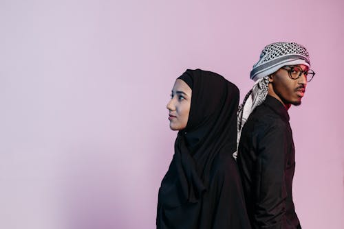 A Couple Wearing Black Long Sleeves and Headscarf