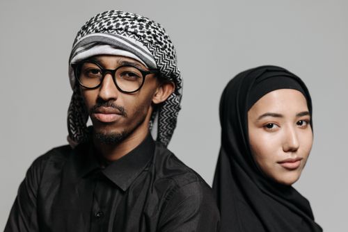 Free Close-up portrait of a young Muslim man and woman in traditional attire, expressing cultural diversity. Stock Photo