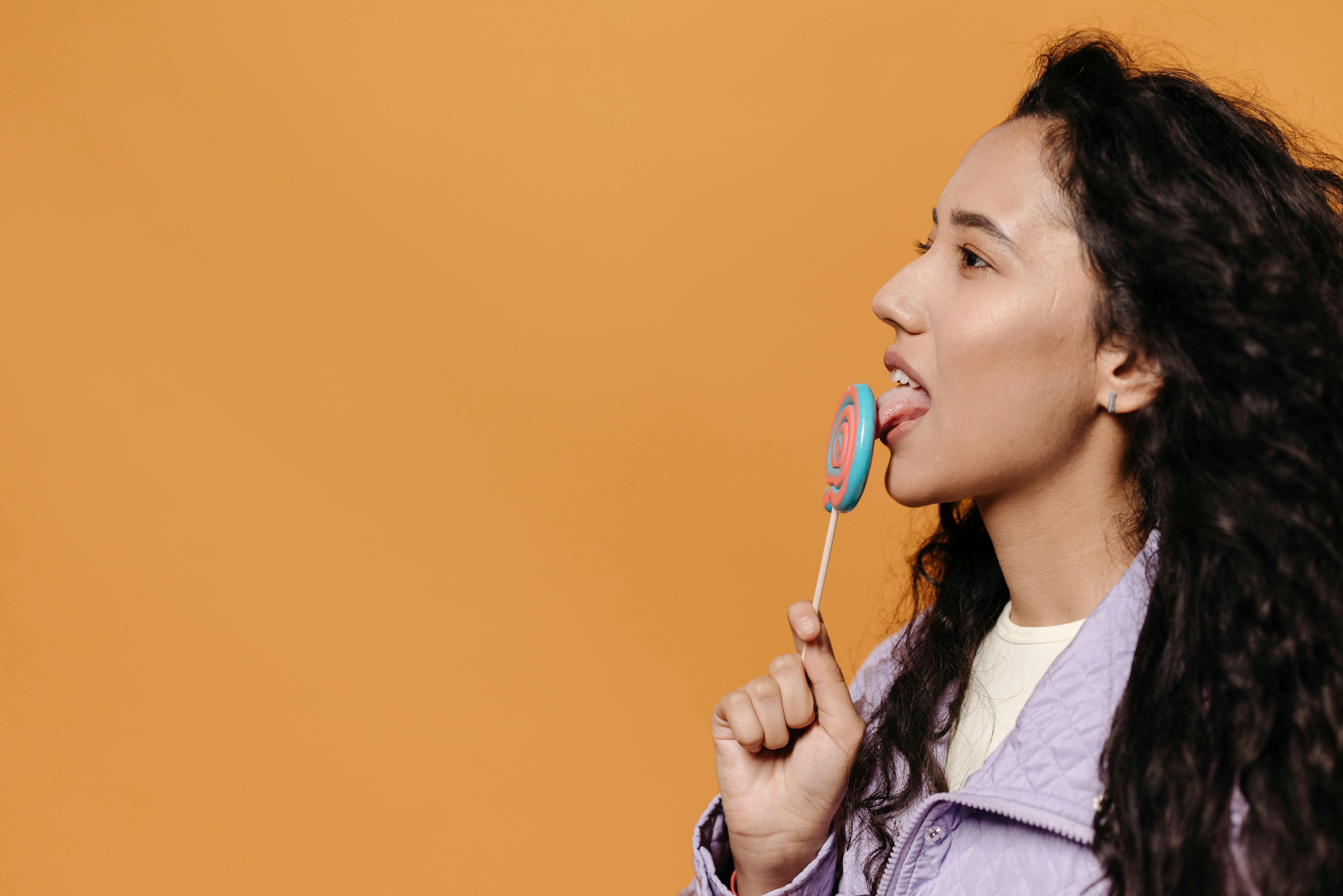 A Woman Licking a Lollipop · Free Stock Photo