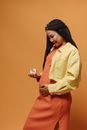 Pregnant Mother in Orange Dress Looking at Her Tummy