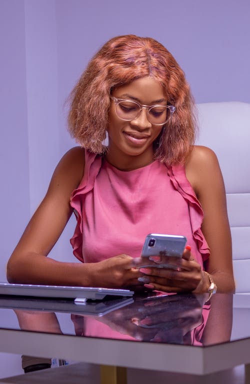 Woman Wearing Pink Dress Using a Smartphone