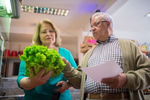 Free Man and Woman Picking Vegetable in the Grocery Stock Photo