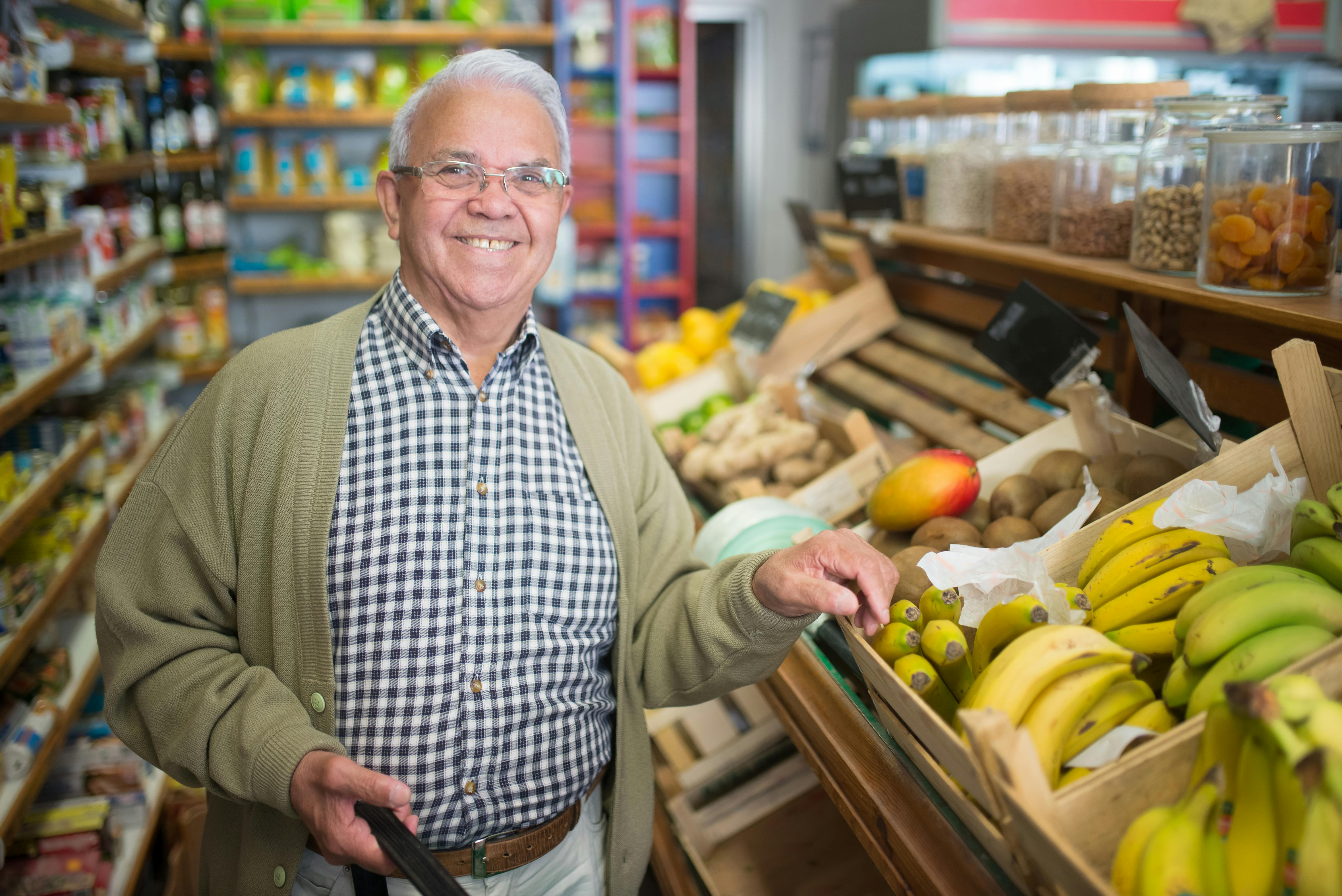 smiling elderly man buying groceries