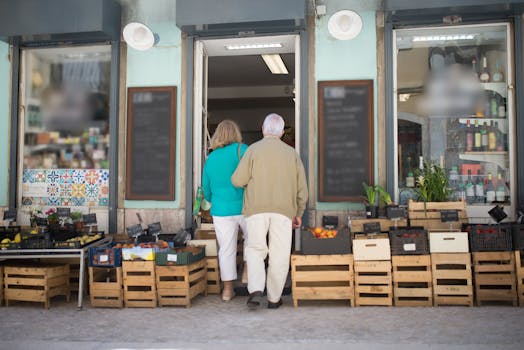 Elderly couple entering a local Portuguese shop surrounded by fresh produce crates.