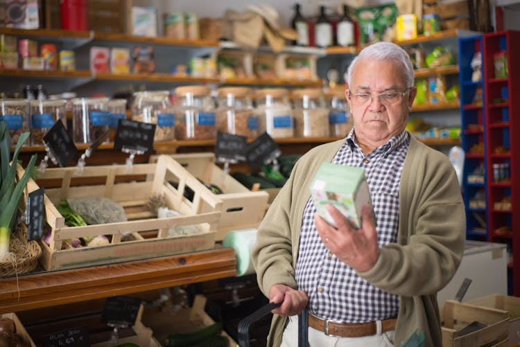 An Elderly Man Looking At A Box