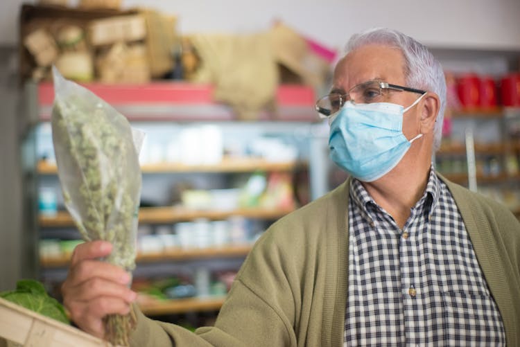 A Man In A Face Mask Shopping At The Grocery