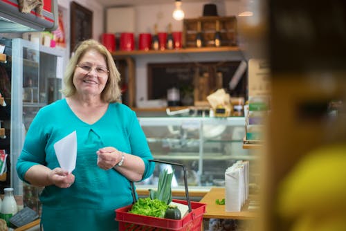 Woman in Teal Shirt Holding Red Basket