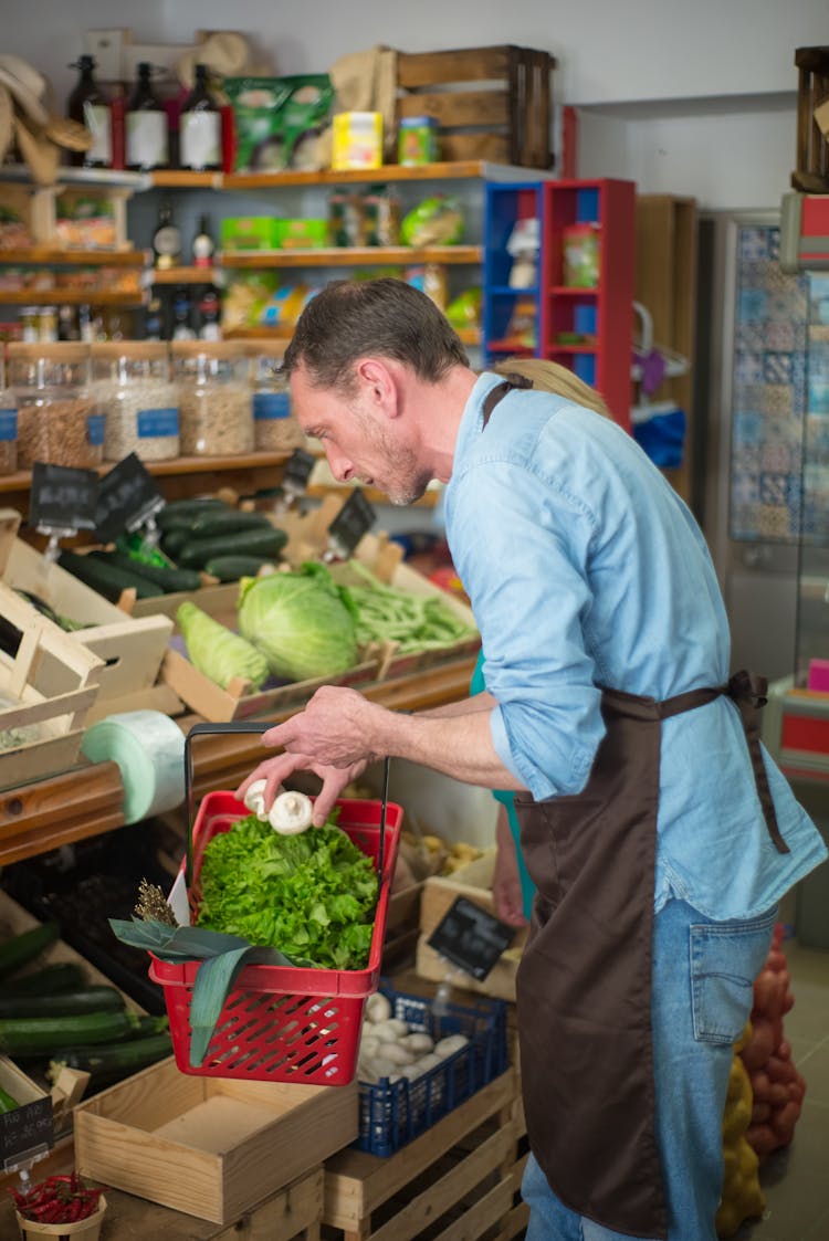 Man With An Apron Carrying A Grocery Basket