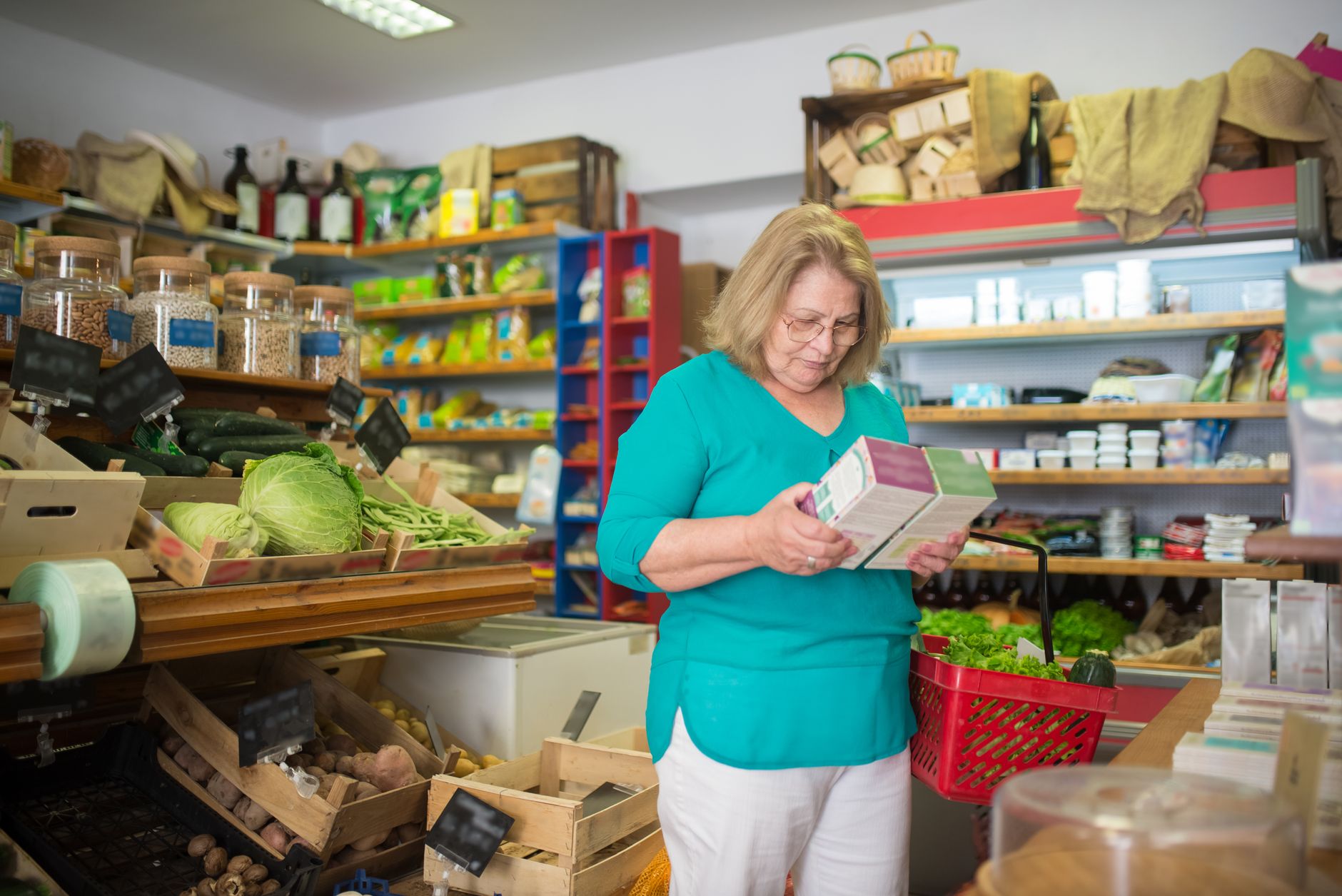 Woman holding a food package, reading the nutrition label carefully
