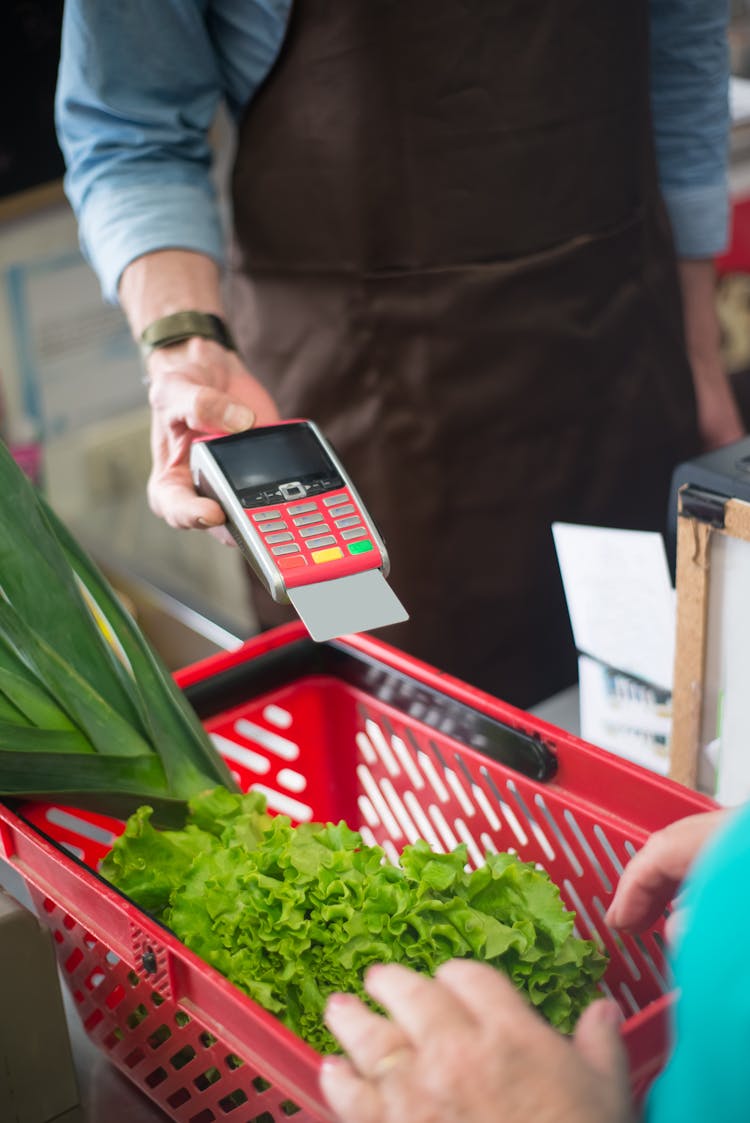 A Clerk Holding A Payment Terminal