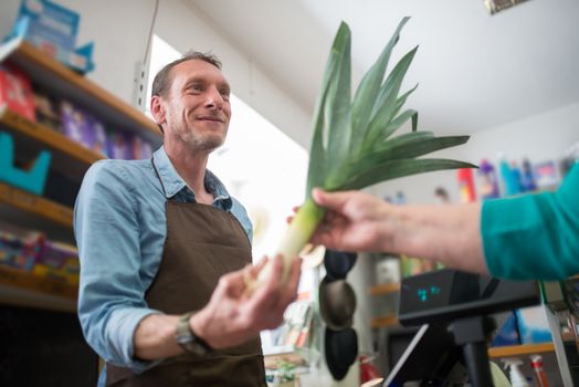 A Store Clerk Handing Out a Leek
