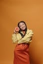 Woman in Yellow Jacket and Red Skirt Holding White Ceramic Mug