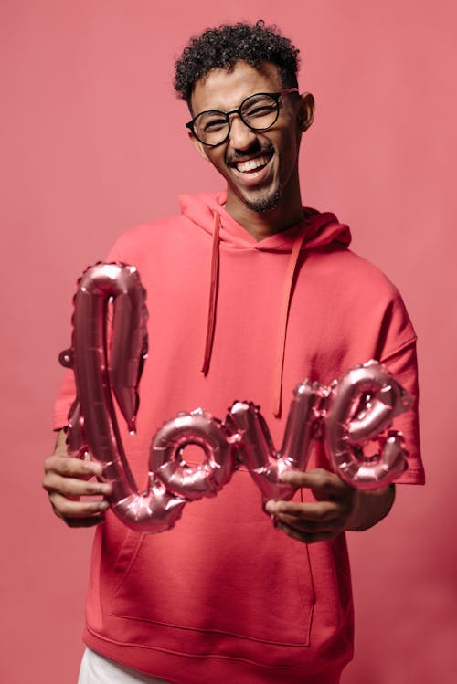 Man in Red Hoodie Holding Pink Balloon