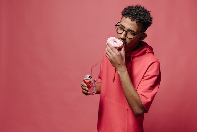 Man In Red Hoodie Eating Donut