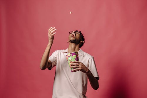 Photo of a Man Throwing Food into his Mouth