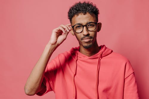 Man in Red Hoodie Holding his Black Framed Eyeglasses