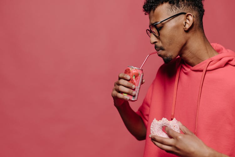 Man In Red Hoodie Drinking Using Red Straw