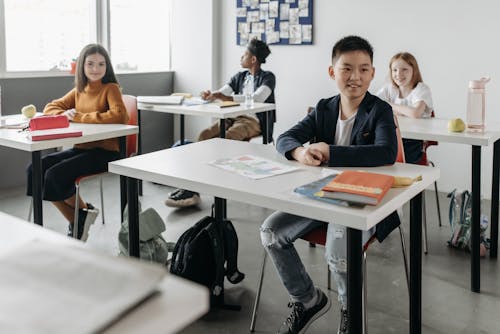 Free Students Sitting by Their Desks Inside the Classroom Stock Photo