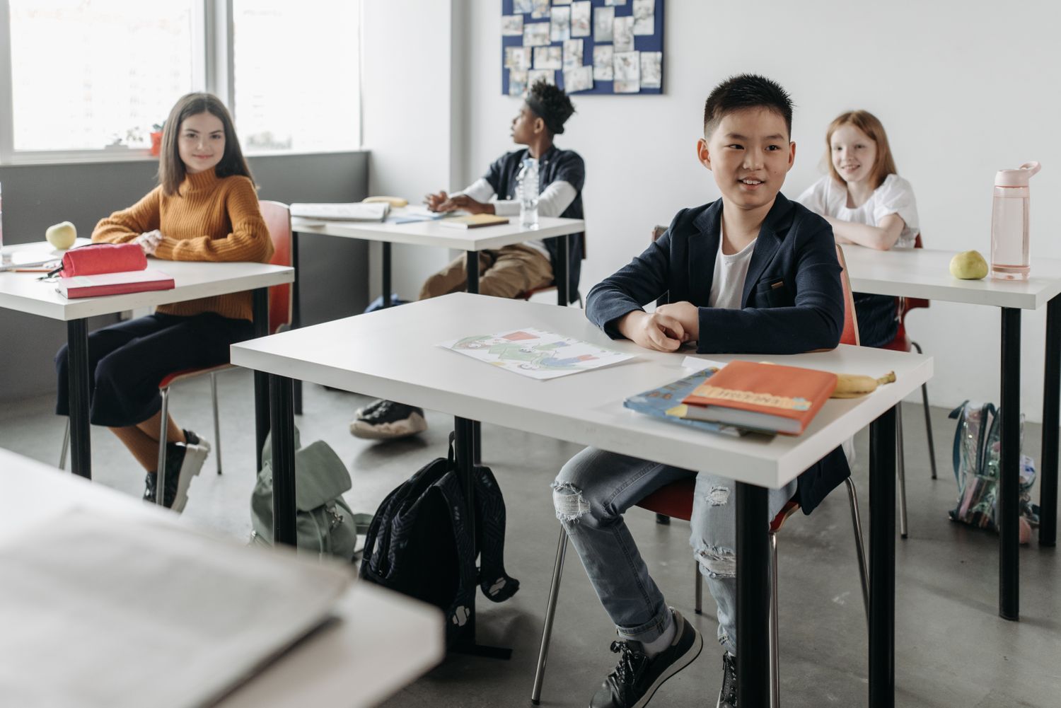 A diverse group of children attentively learning in a modern classroom setting.
