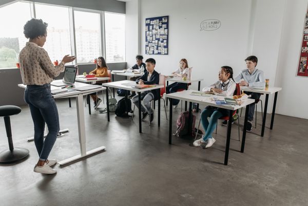 Teacher and students in a classroom representing education