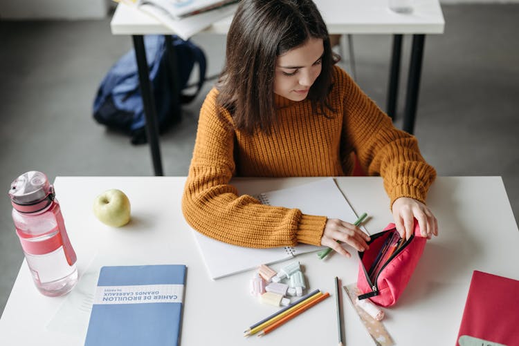 Girl In Knitted Sweater Opening Her Pencil Case