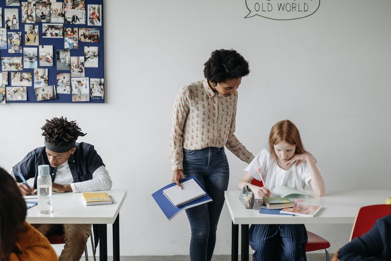 An adult supporting learners during a classroom activity