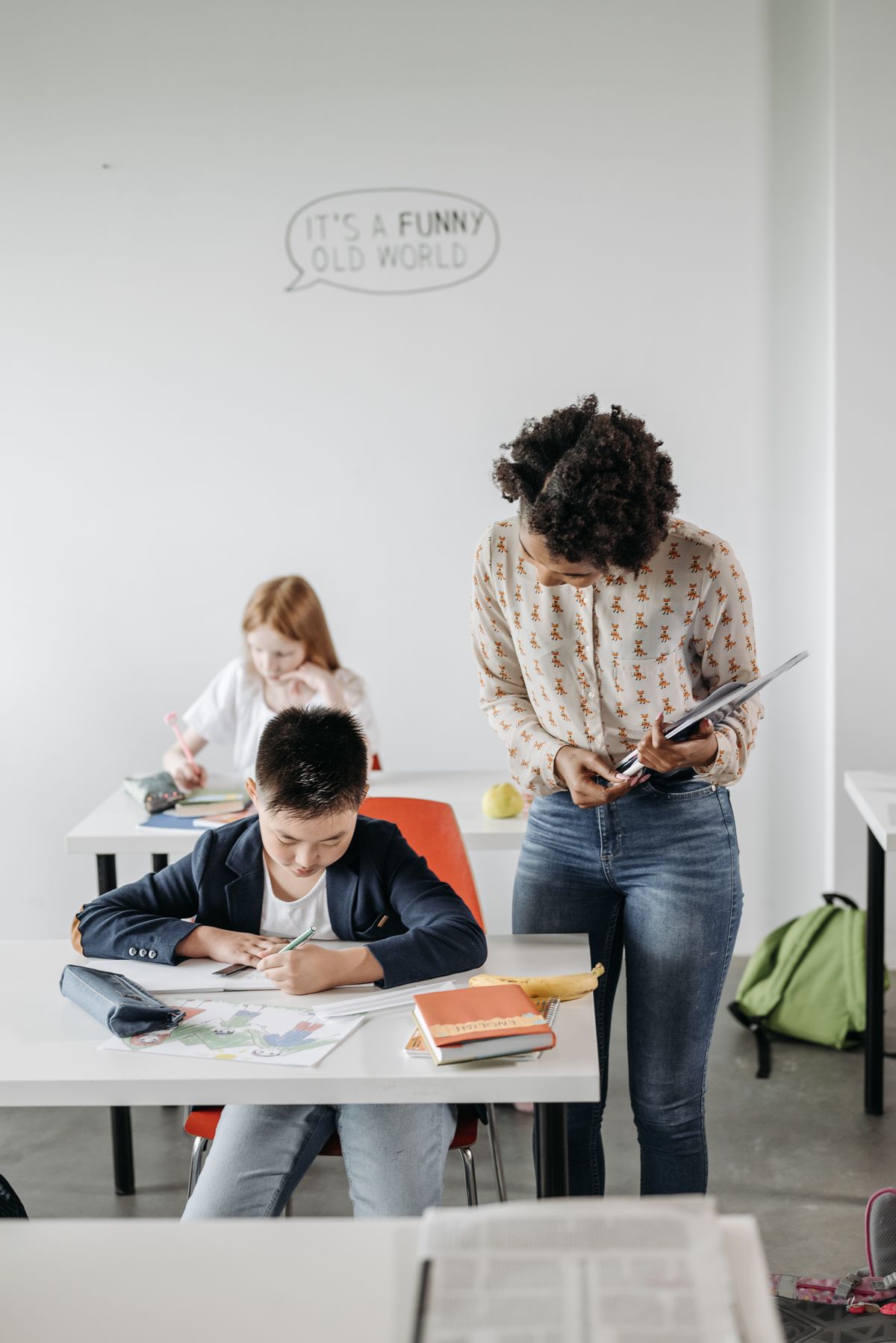 Maestra guiando a estudiantes en un aula moderna