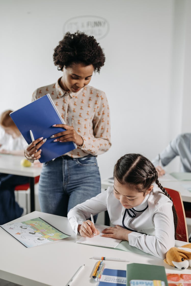 A Teacher Looking At Her Students School Work