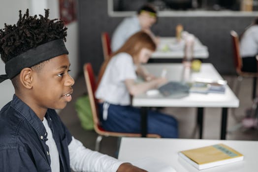 Black child sitting attentively in a classroom setting, focusing on learning.