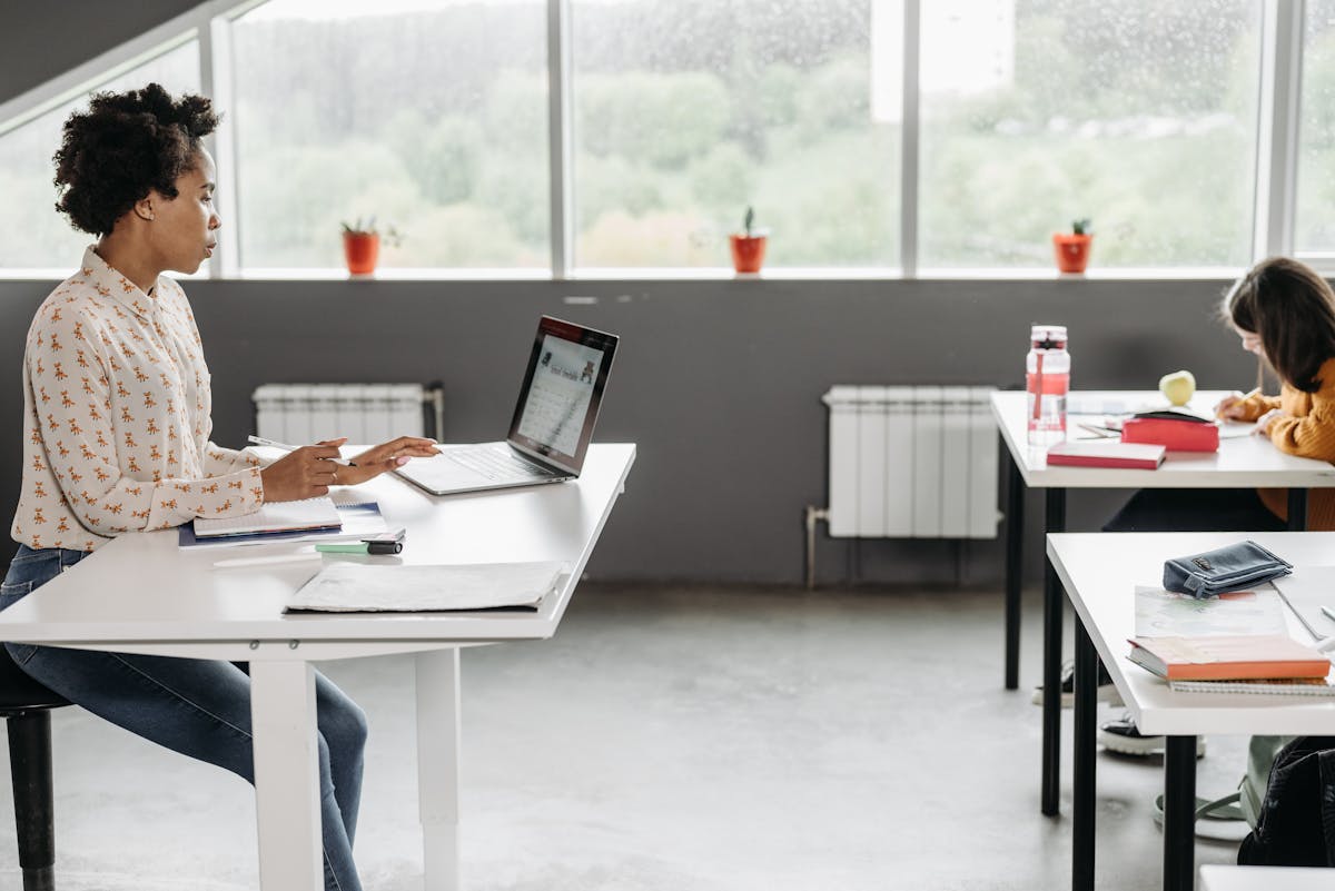 Insegnante seduta a una scrivania che lavora al laptop