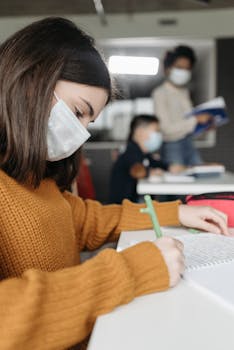 Students wearing masks participate in classroom activities during pandemic.